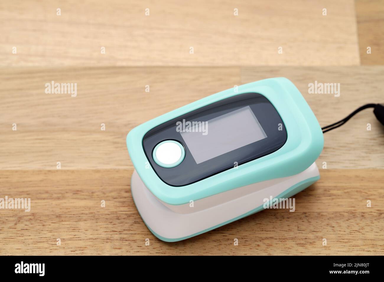 Pulse oximeter device on wooden table, healthcare monitoring concept Stock Photo