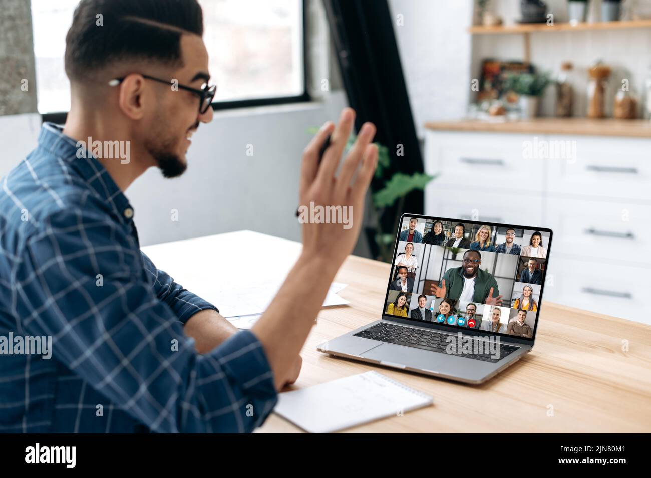 Group brainstorm, online video meeting, virtual conference with multiracial colleagues. Mixed race man communicate with business partners by video call uses laptop and app, work from home, greeting Stock Photo