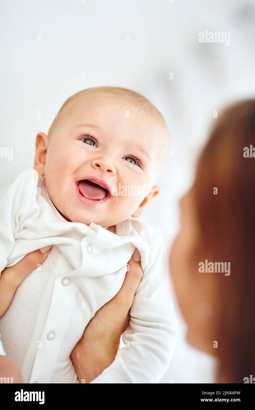 Cute, little and happy baby in the arms of his mother or single parent. Innocent, pure and adorable newborn infant with his mom. Bonding together as a Stock Photo