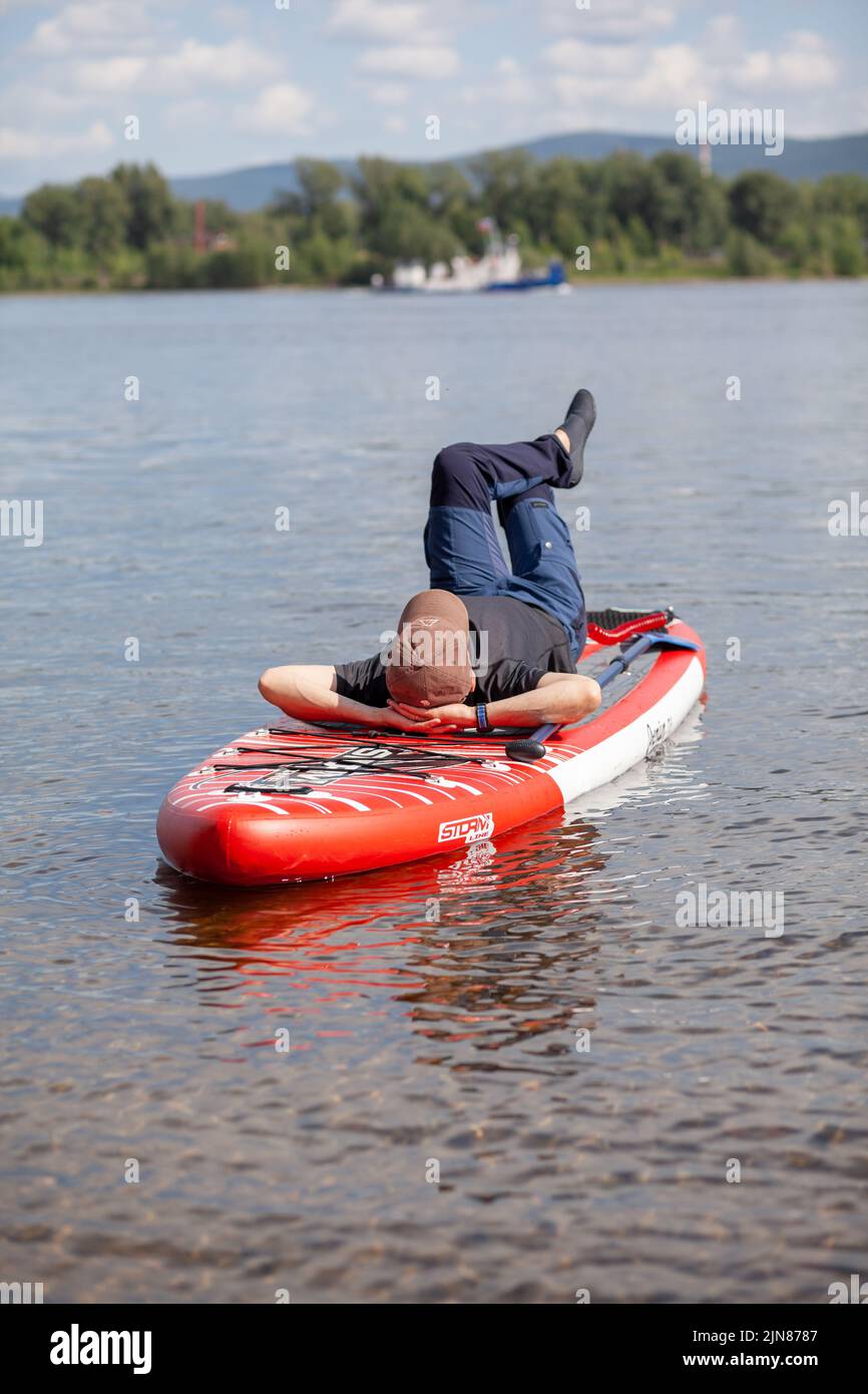 SUP board Stand up paddle man boarding on lake standing happy on blue