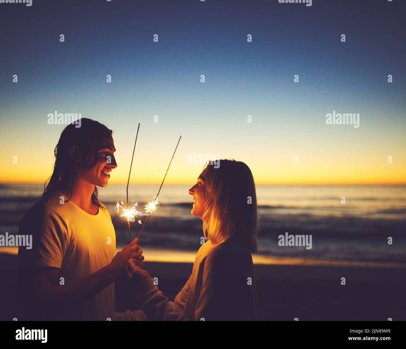 Hejse Patent sammenholdt Within you is the light of a thousand suns. a young couple playing with  sparklers on the beach at night Stock Photo - Alamy