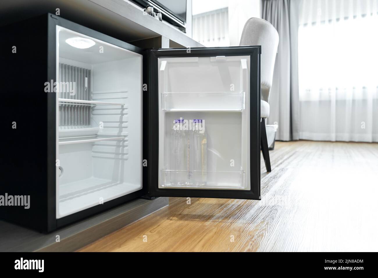 Black mini small fridge refrigerator under the frame wooden counter in