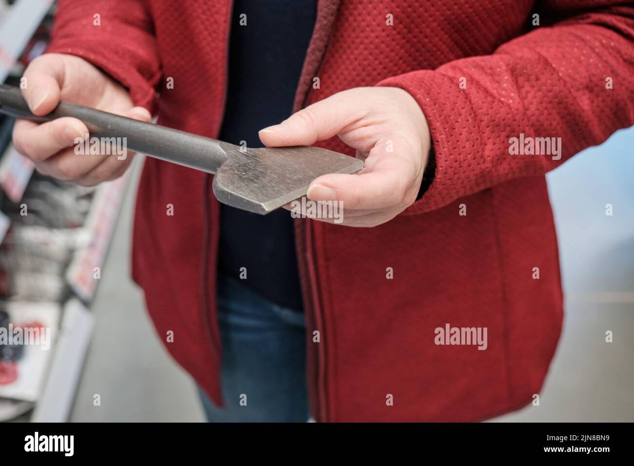 Woman in building materials store chooses for buy wide drill for