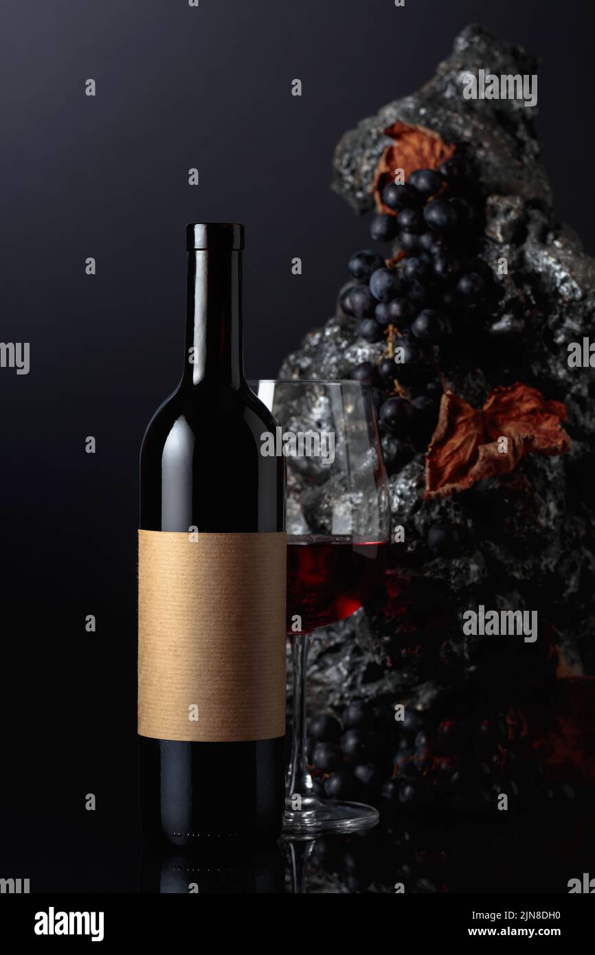 Bottle of red wine with empty label. In the background rough grey stone
