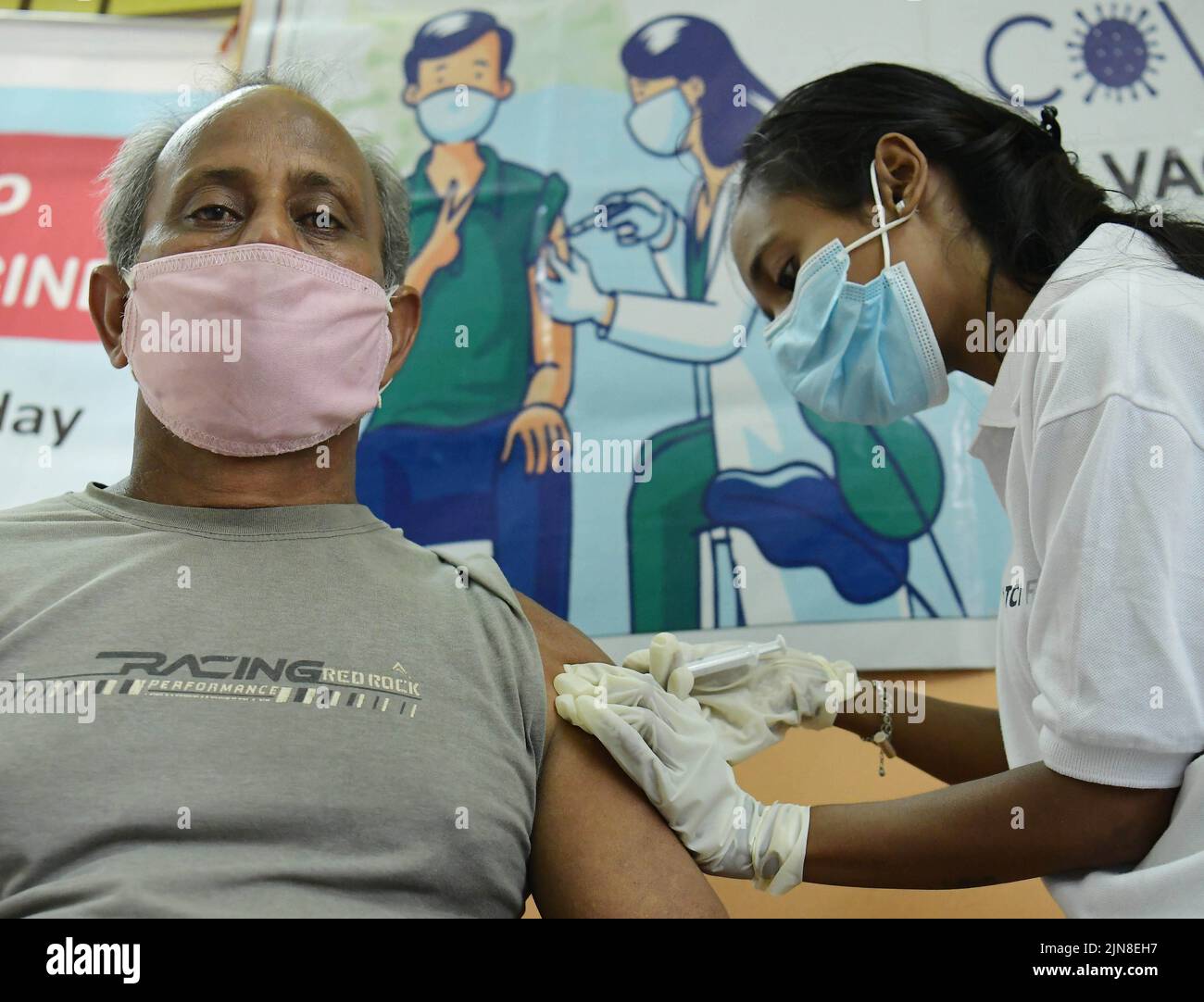 A health worker administers the third dose (Booster Dose) of COVID-19 vaccine to a person, at the Tripura Wholesale grocery Merchants Association in Agartala. Tripura, India. Stock Photo