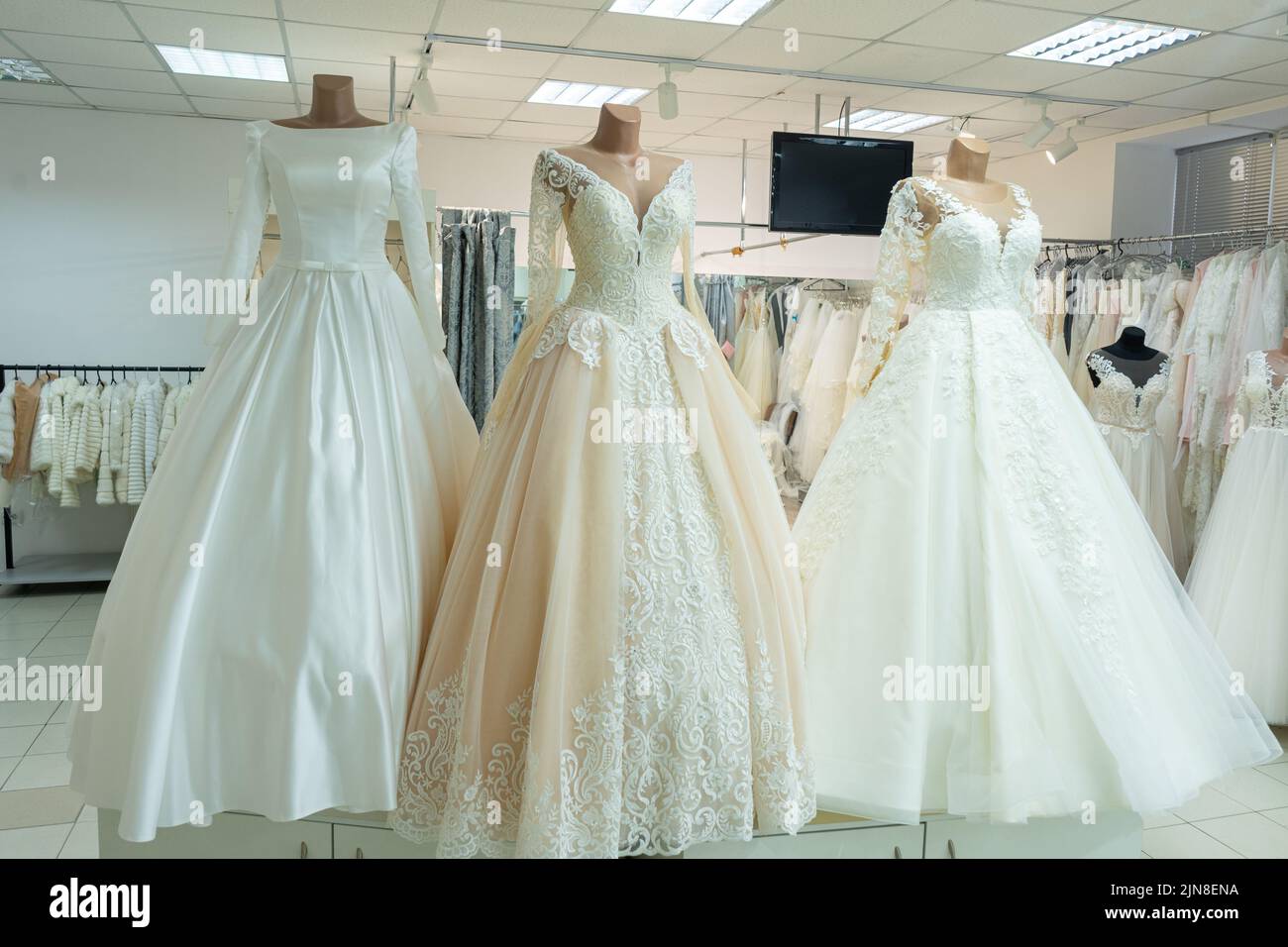 Three chic wedding dresses on mannequins. Three different models of beautiful wedding dresses. Stock Photo