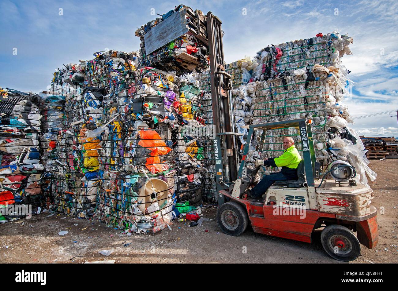 Fork lift stacking bales of miscellaneous plastics for recycling at a recycling plant in Geelong, Victoria Stock Photo