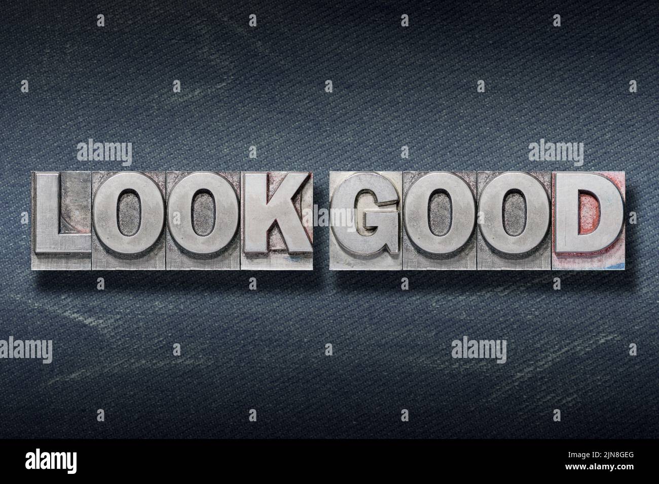 look good phrase made from metallic letterpress on dark jeans background Stock Photo
