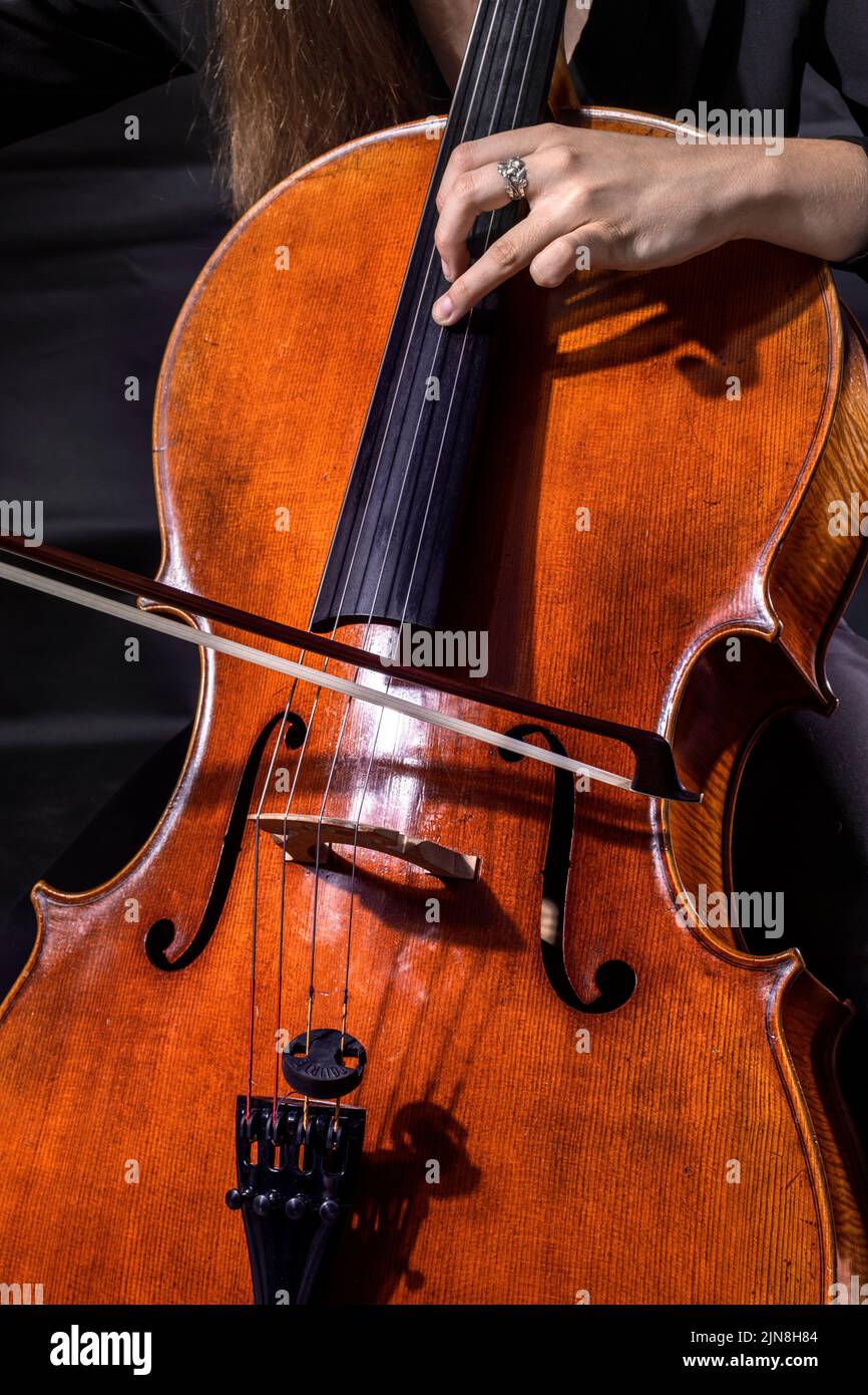 Beautiful girl professional cellist playing antique cello Stock Photo