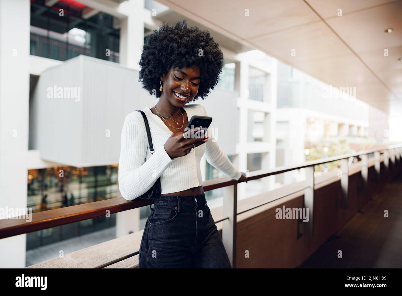 Beautiful young african woman using mobile phone in the street Stock Photo