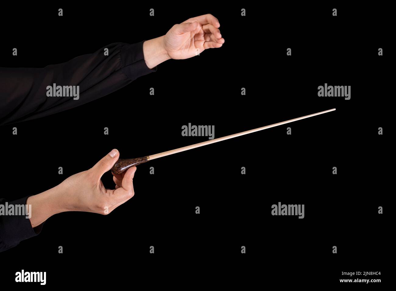 Female conductor conducting a symphony with her baton on a black