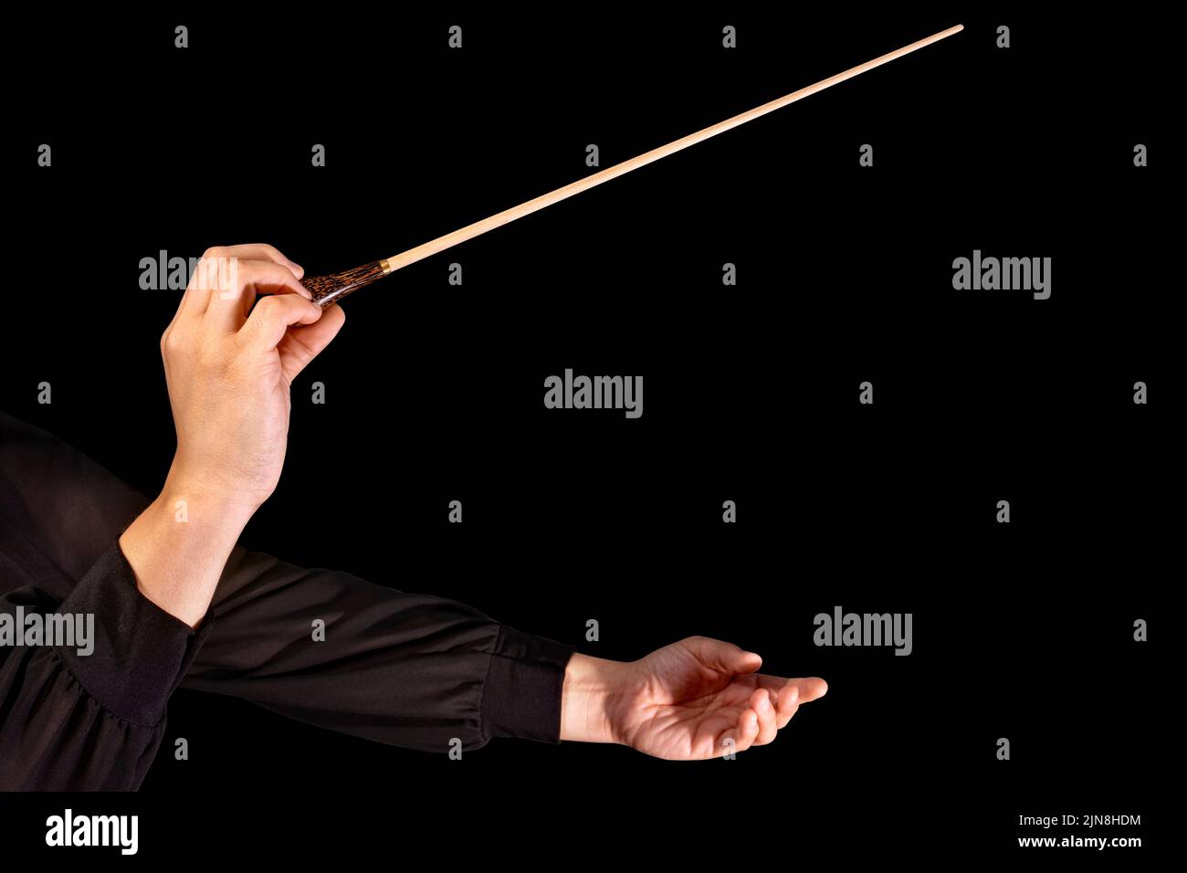 Female conductor conducting a symphony with her baton on a black