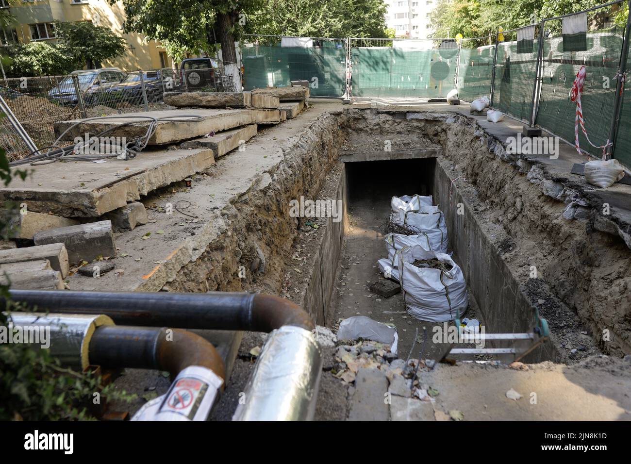 Bucharest, Romania - August 3, 2022: Big hole in the road for workers to repair a RADET (Termoenergetica) pipeline in Bucharest. Stock Photo