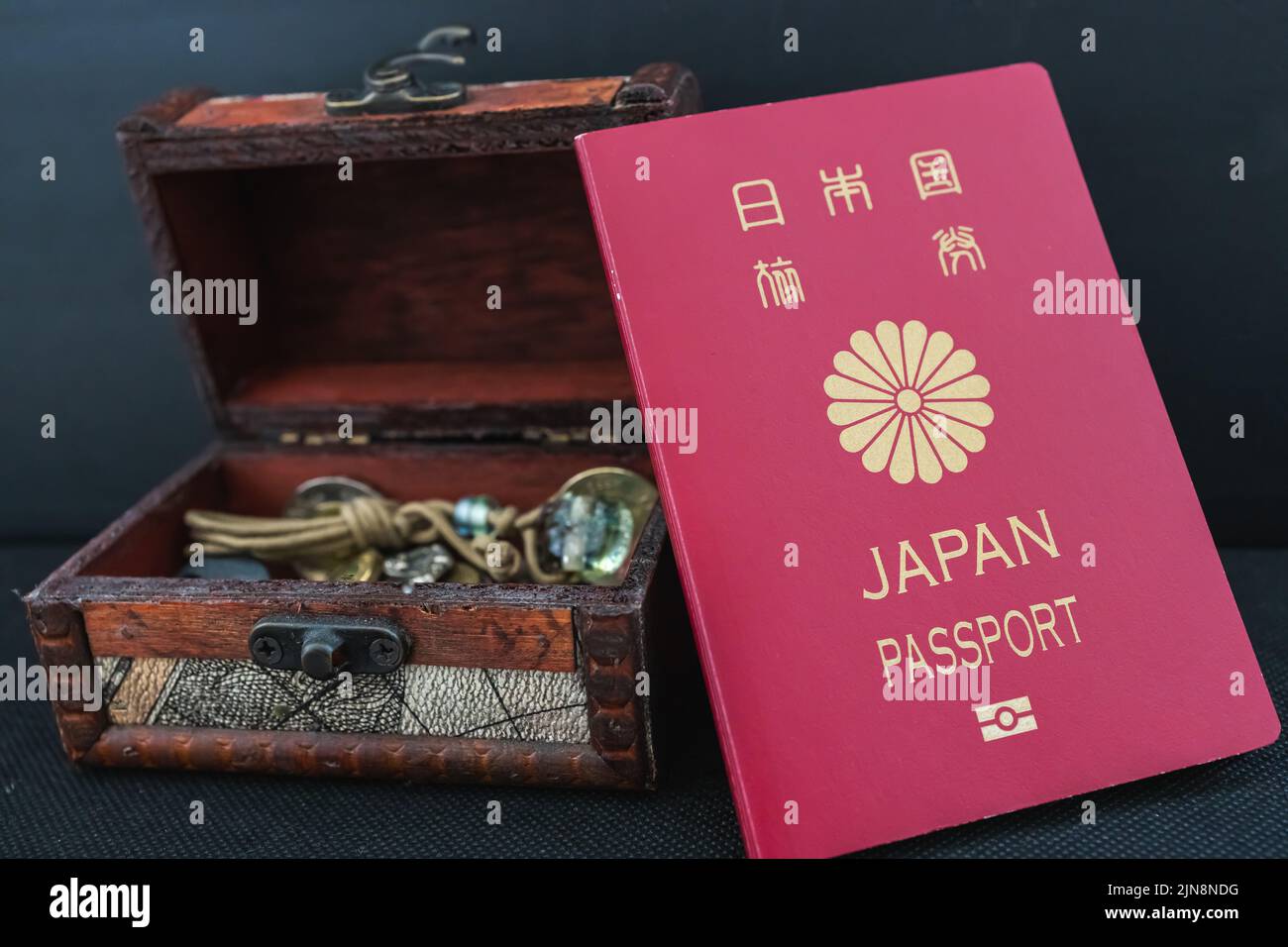 A photo of Japanese passport and treasure box holding coins inside, the concept of travelling Stock Photo