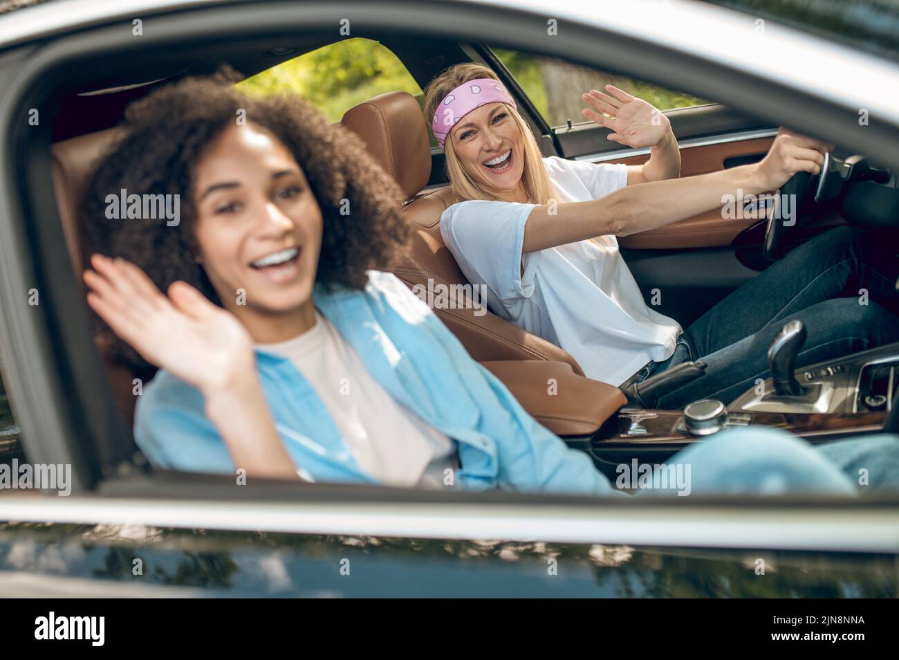 Group of friends driving in a car and looking excited Stock Photo - Alamy
