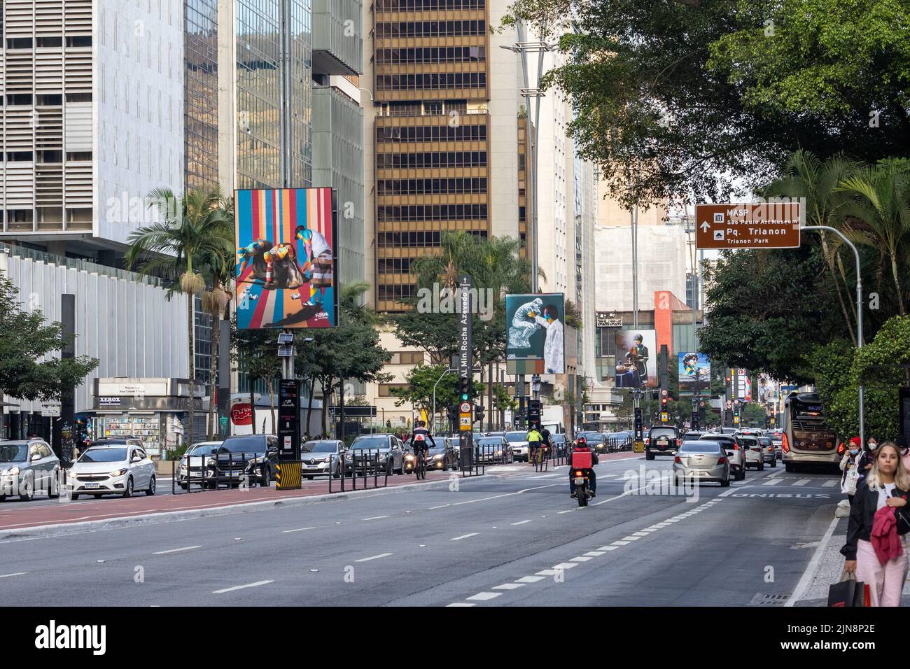 The busy Paulista avenue with traffic, people, billboards, and street signs Stock Photo