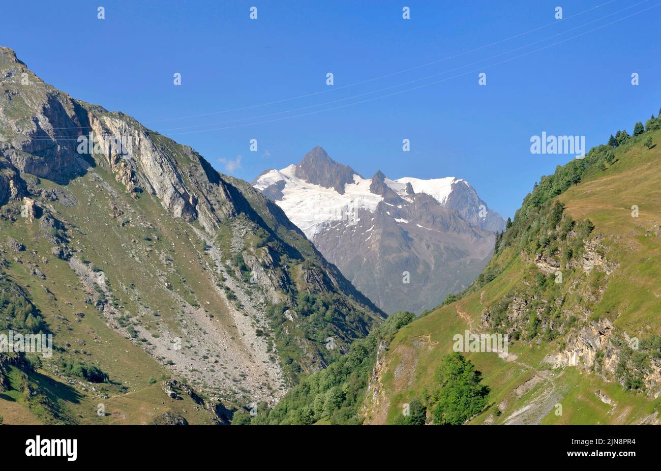 view on a glacier of the Mont Blanc massif between mountains under clear blue sky in Tarentaise Stock Photo
