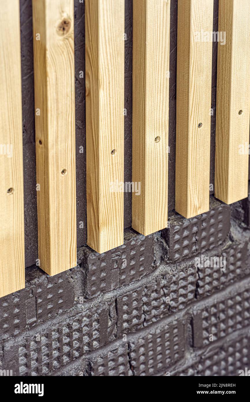 Building wall decorated with stylish wooden slats made of thin light planks on house terrace extreme close view Stock Photo