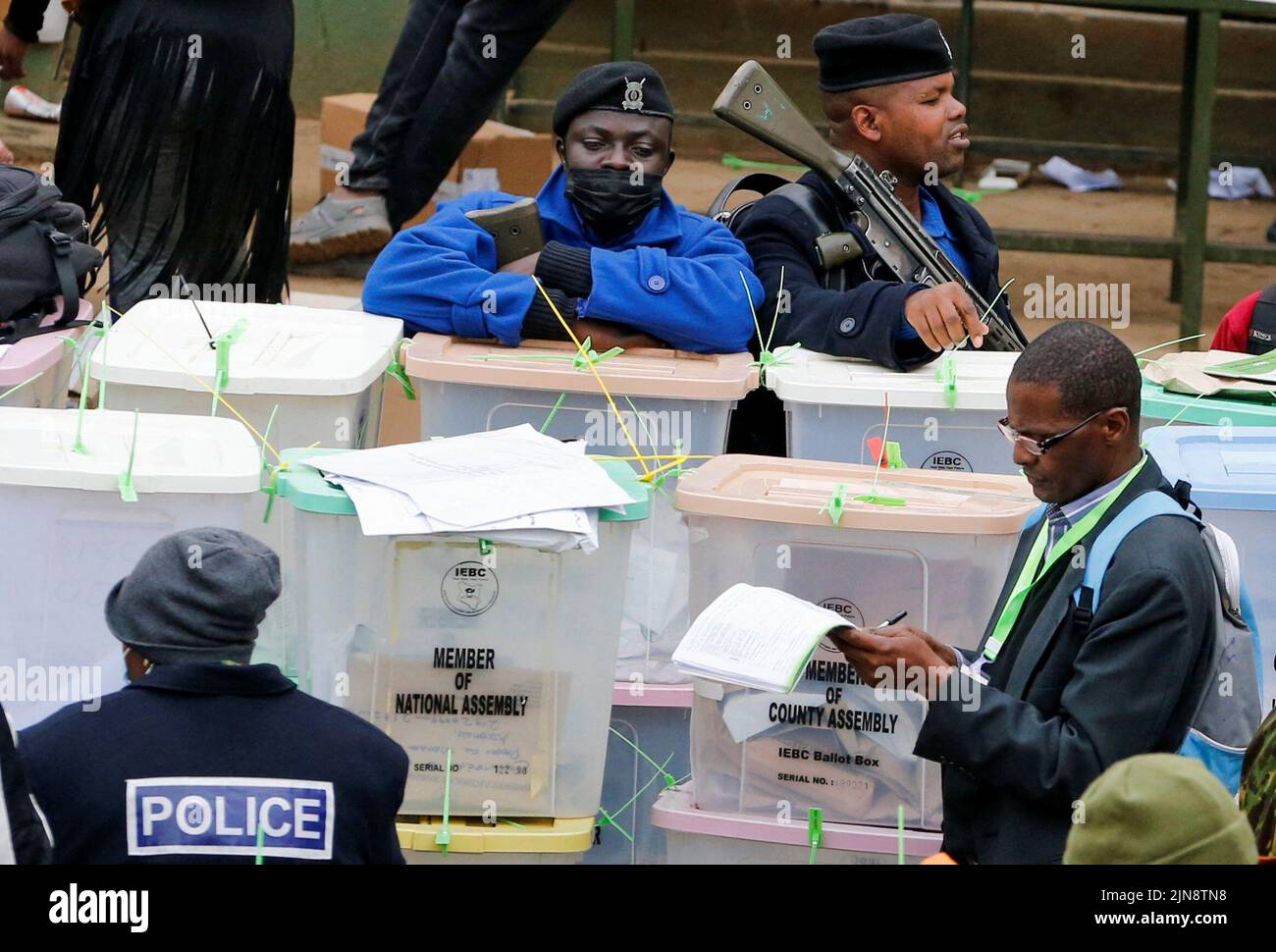 Police officers and polling staff sort sealed ballot boxes containing electoral materials at an Independent Electoral and Boundaries Commission (IEBC) tallying centre after the general election in Nairobi, Kenya August 10, 2022. REUTERS/Thomas Mukoya Stock Photo