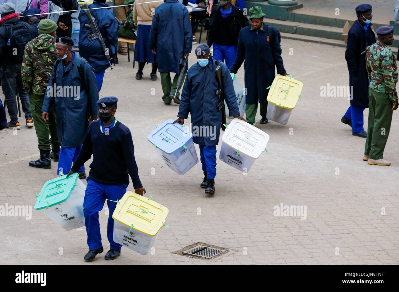 Police officers carry sealed ballot boxes containing electoral materials at an Independent Electoral and Boundaries Commission (IEBC) tallying centre after the general election in Nairobi, Kenya August 10, 2022. REUTERS/Thomas Mukoya Stock Photo