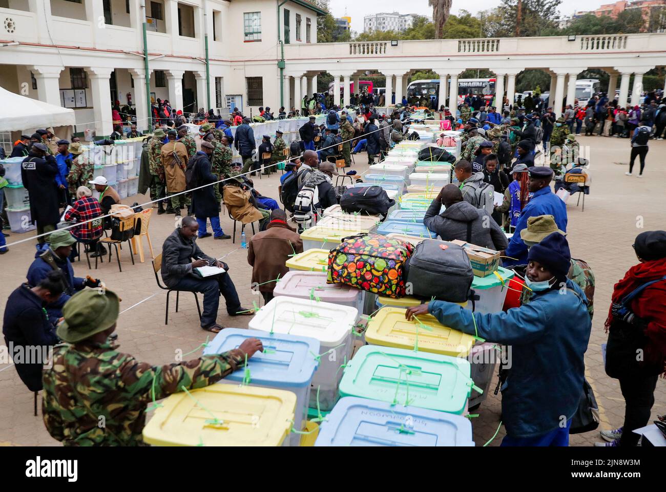 Police officers and polling staff sort sealed ballot boxes containing electoral materials at an Independent Electoral and Boundaries Commission (IEBC) tallying centre after the general election in Nairobi, Kenya August 10, 2022. REUTERS/Thomas Mukoya Stock Photo