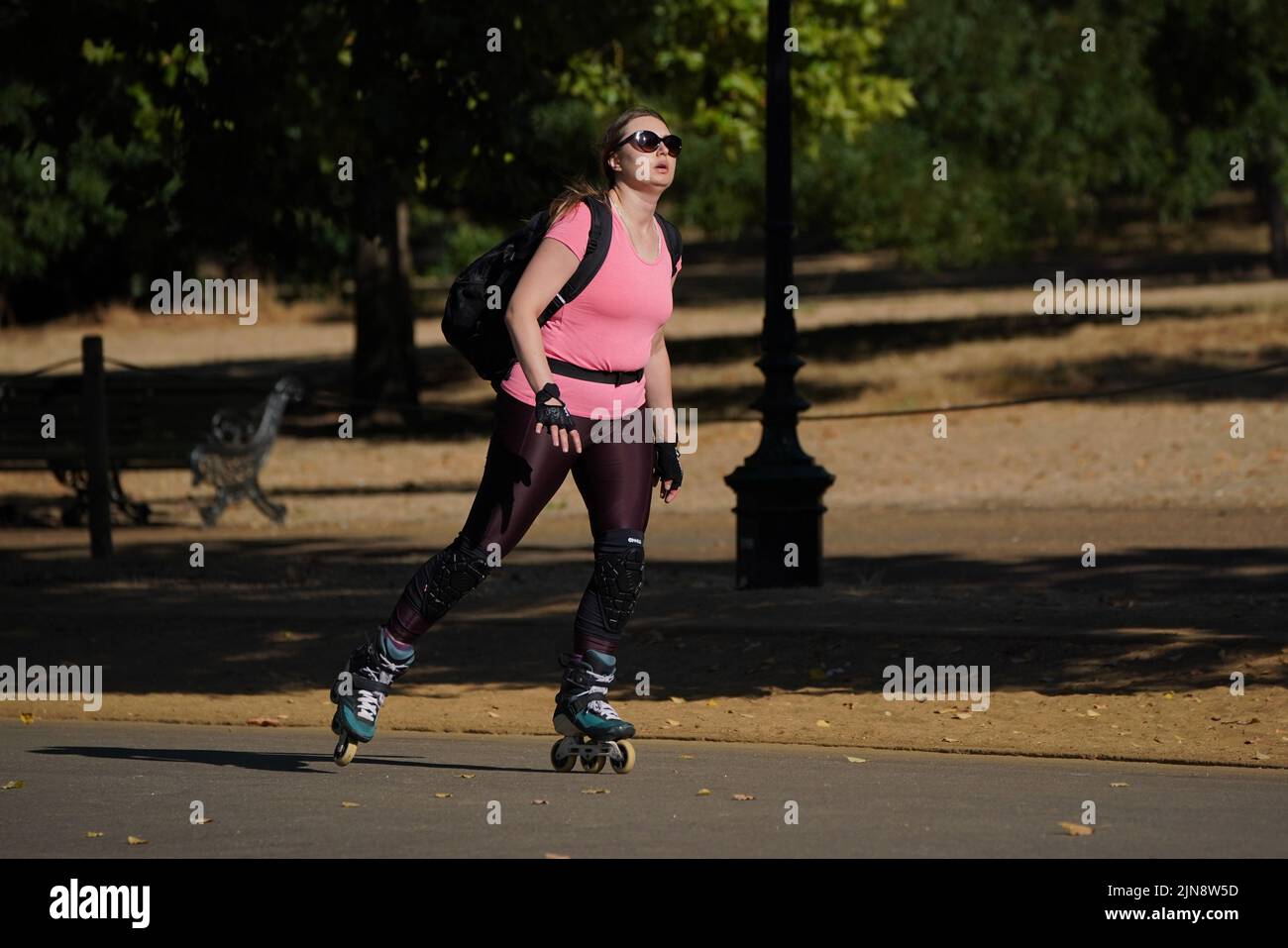 A woman roller skates during the hot weather in Hyde Park, London. The Met Office has issued an amber warning for extreme heat covering four days from Thursday to Sunday for parts of England and Wales as a new heatwave looms. Picture date: Wednesday August 10, 2022. Stock Photo