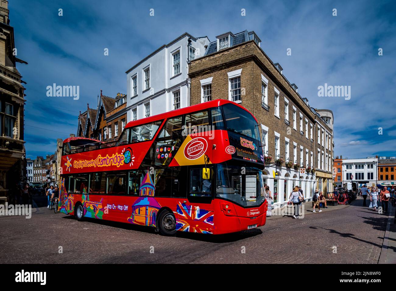 Cambridge Tourism. An open top tourist bus drives through the narrow streets of Cambridge historic centre. Tourism impact Cambridge UK. Stock Photo