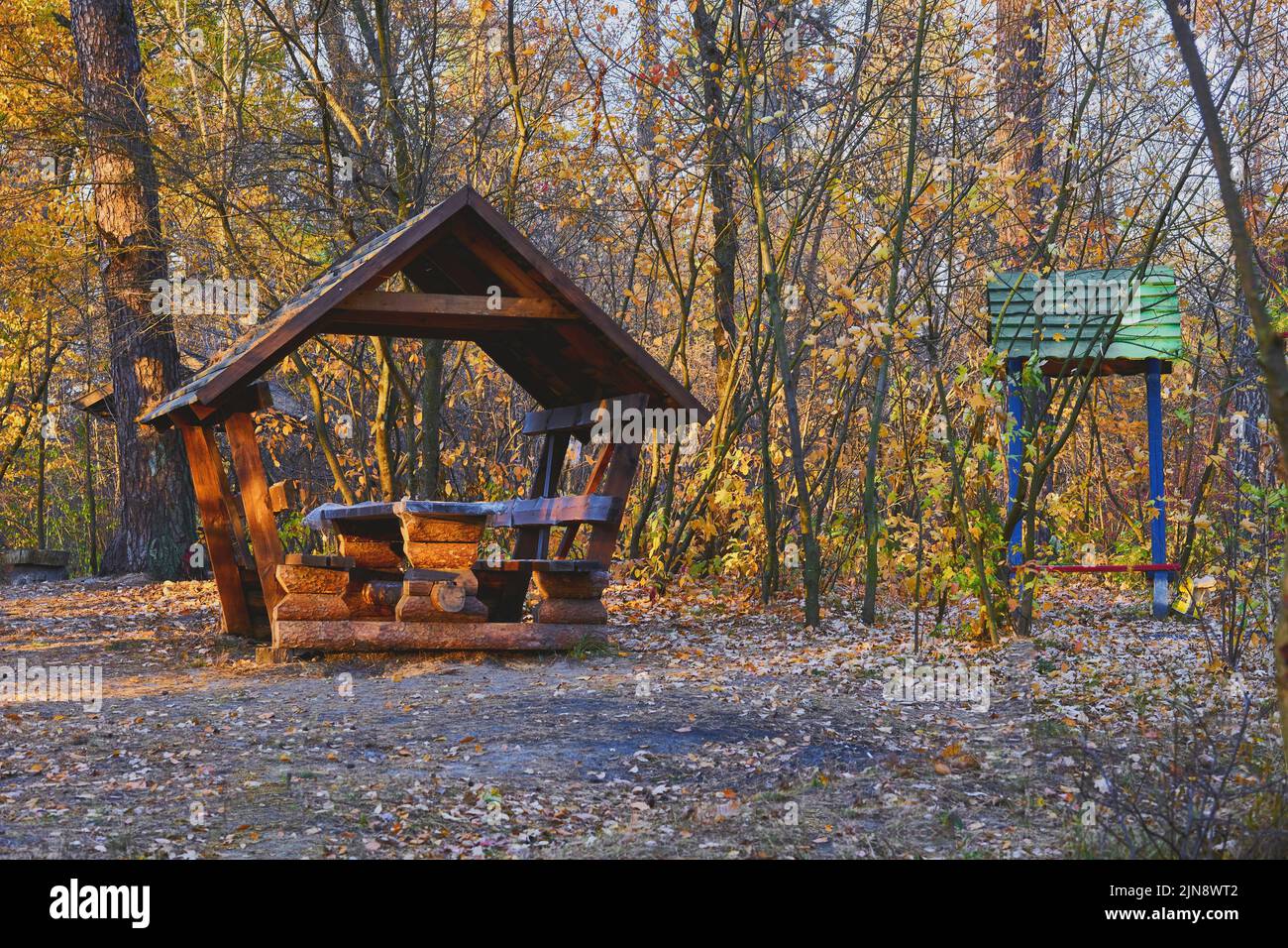 Autumn picnic. Wooden gazebo house in a forest clearing for recreation camping Stock Photo