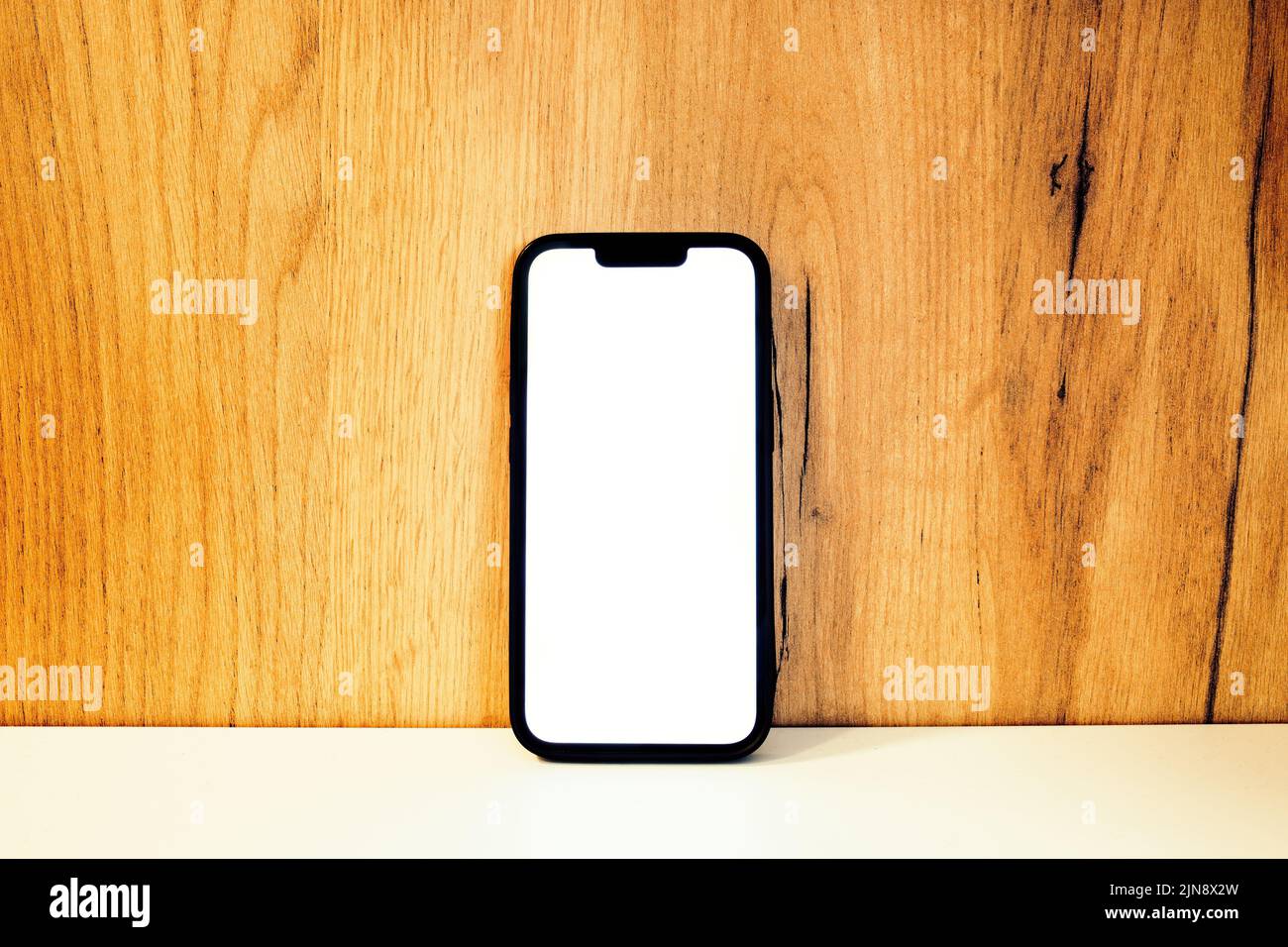 Smartphone mockup, mobile phone with blank screen on wooden shelf, copy space included Stock Photo