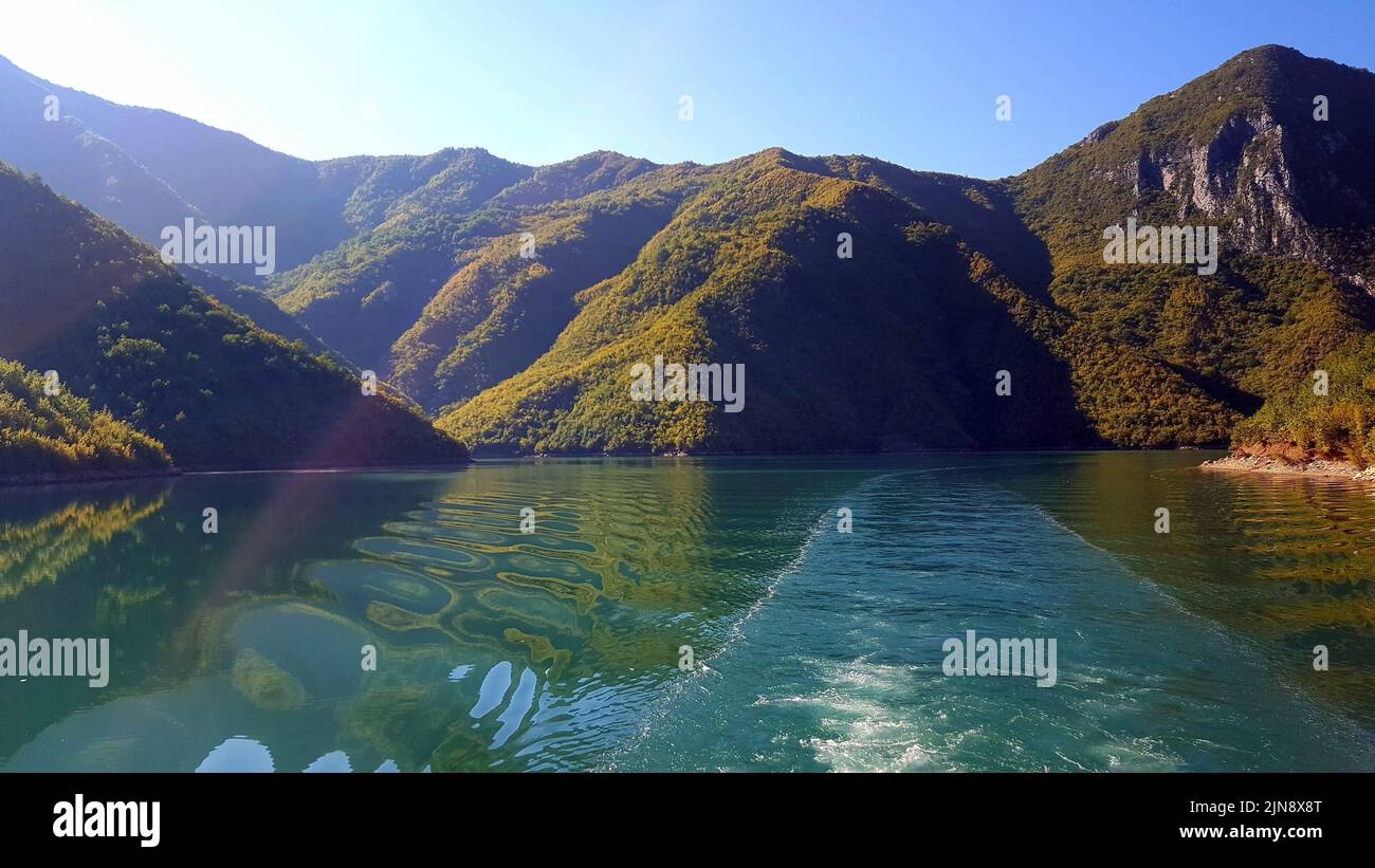 Lake Koman is a reservoir on the Drin River in northern Albania, surrounded by dense forested hills, vertical slopes, deep gorges and a narrow valley Stock Photo