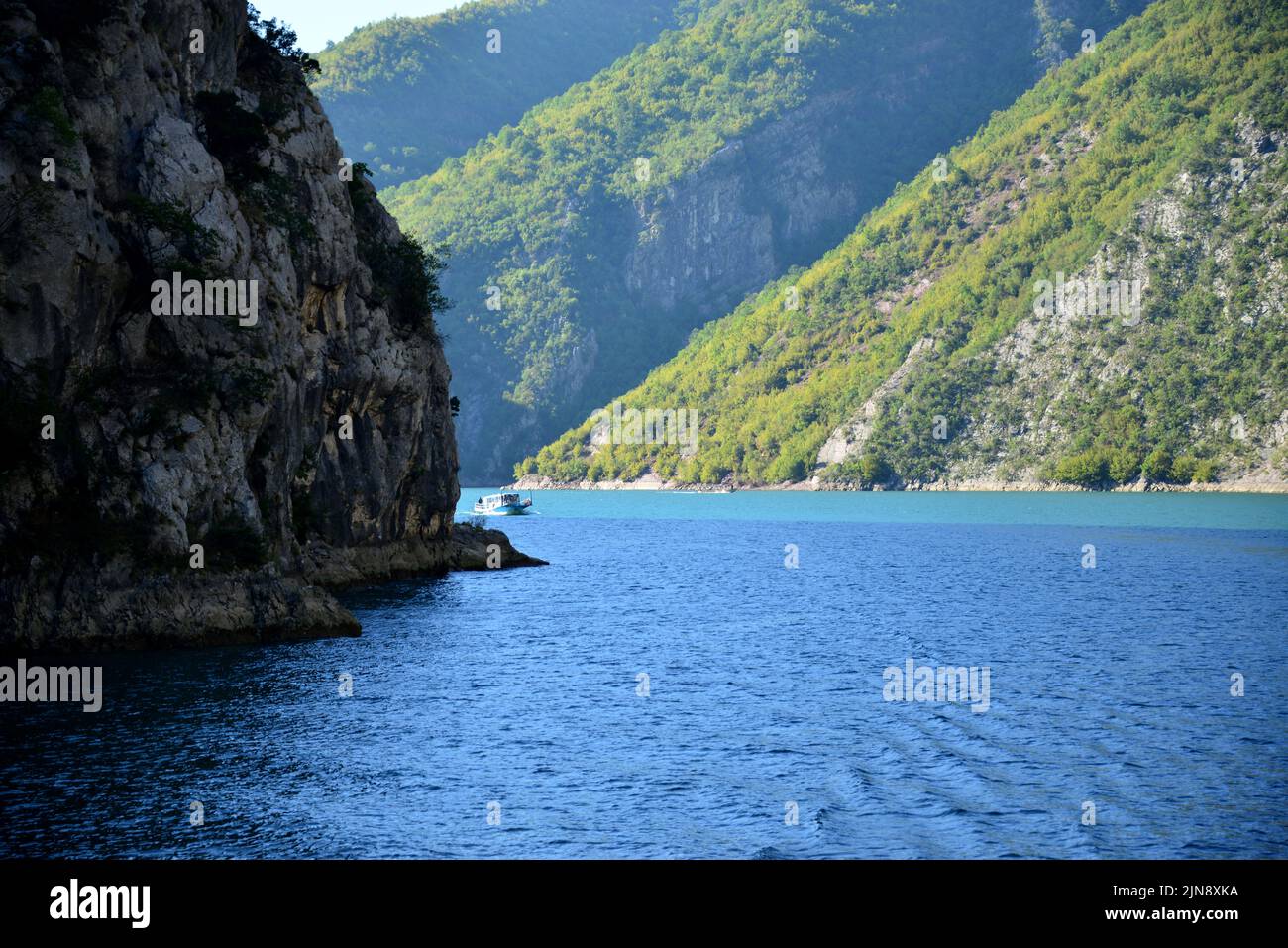 Lake Koman is a reservoir on the Drin River in northern Albania, surrounded by dense forested hills, vertical slopes, deep gorges and a narrow valley Stock Photo