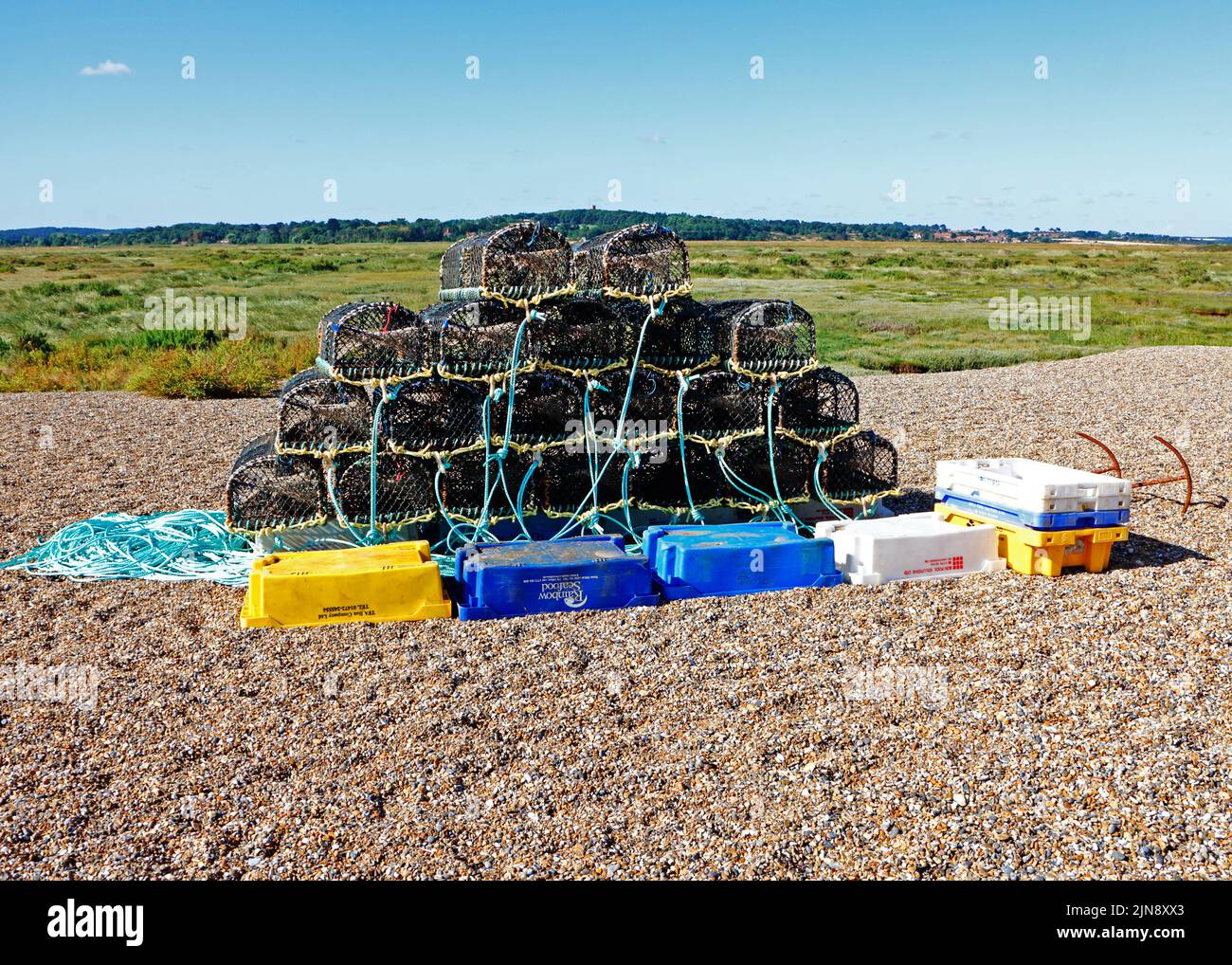 A store of crab/lobster pots and fish boxes on the shingle beach in North Norfolk at Cley-next-the-Sea, Norfolk, England, United Kingdom. Stock Photo