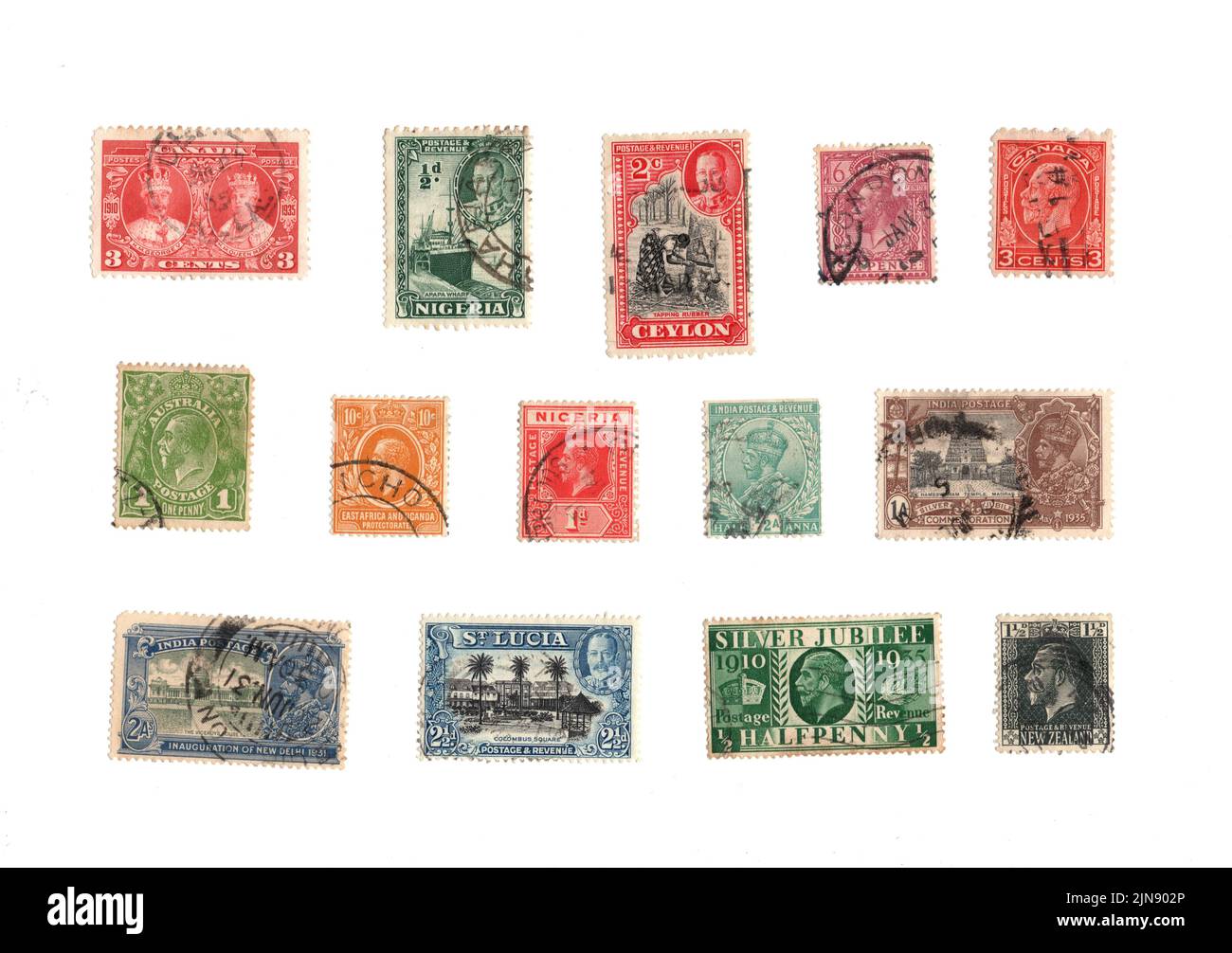 A selection of old George V postage stamps from around the world on a white background. Stock Photo