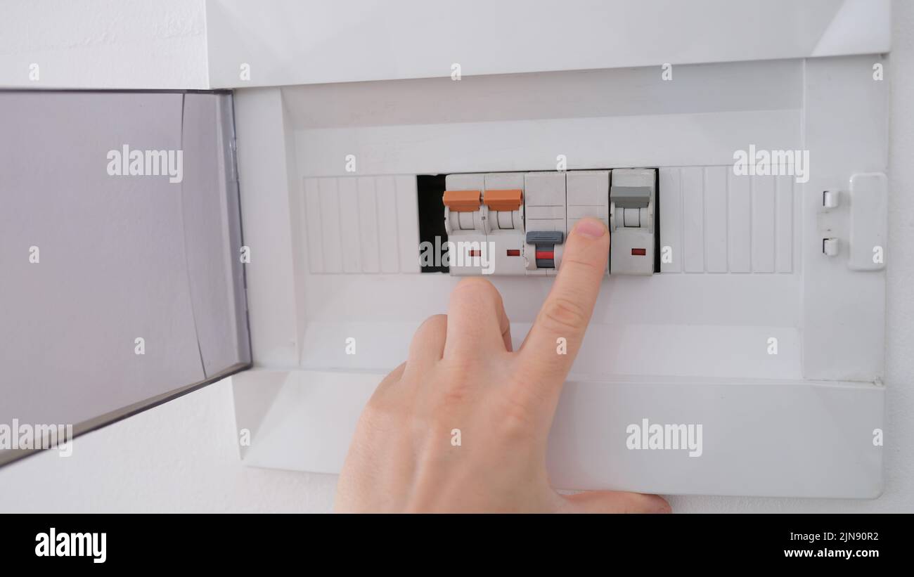 Many switches displayed on circuit breaker board. Fnger is about to
