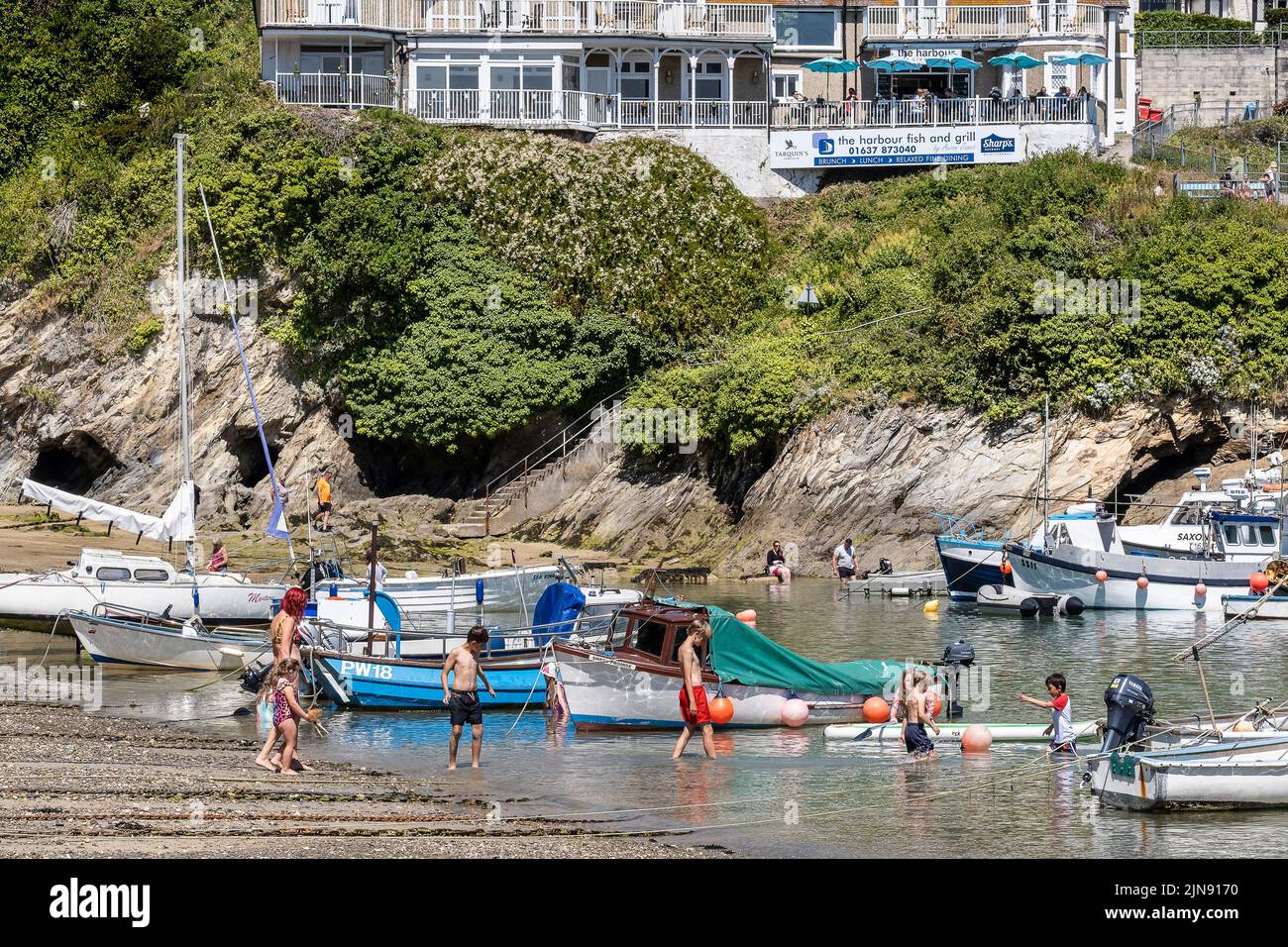 Fishing boats and Sailboats moored in the picturesque Newquay Harbour in Cornwall in England in the UK. Stock Photo