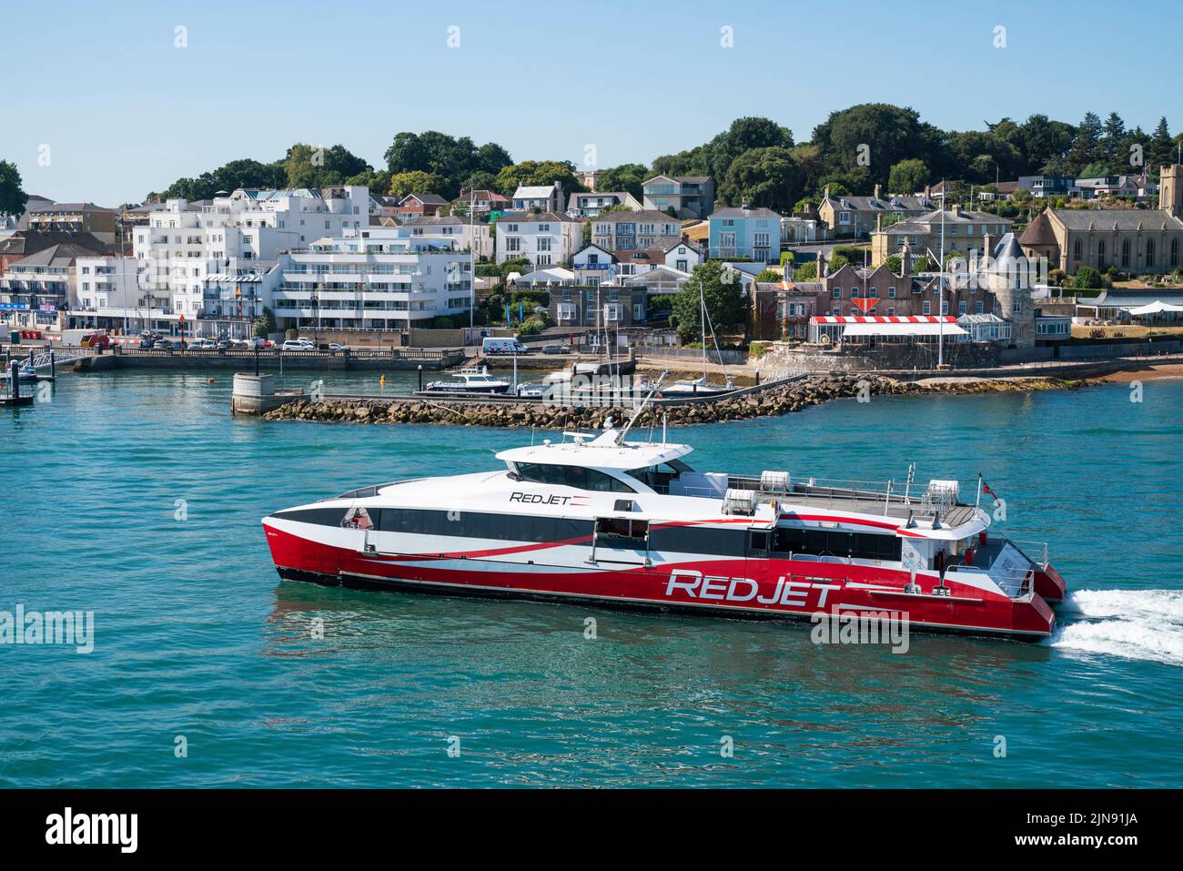 The Red Jet, a high speed catamaran operated by Red Funnel, makes its way in to West Cowes on the Isle of Wight in the summer holidays. Stock Photo