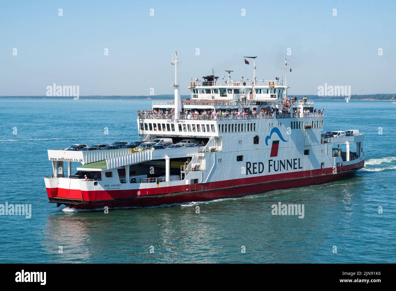 The Red Funnel vehicle ferry 'Red Osprey' makes its way into Cowes harbour on the Isle of Wight packed with holiday makers. Stock Photo