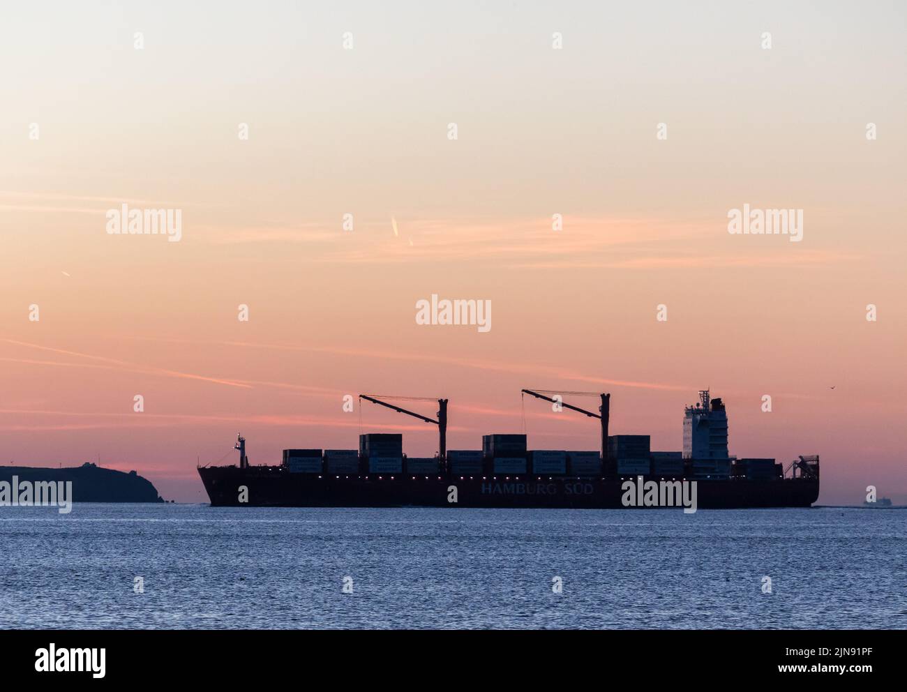 Myrtleville, Cork, Ireland. 10th August, 2022. After a ten day voyage from Costa Rica container ship Polar Colombia is silhouetted by dawn light as she arrives at the mouth of the Cork Harbour, Ireland.  - Picture David Creedon Stock Photo