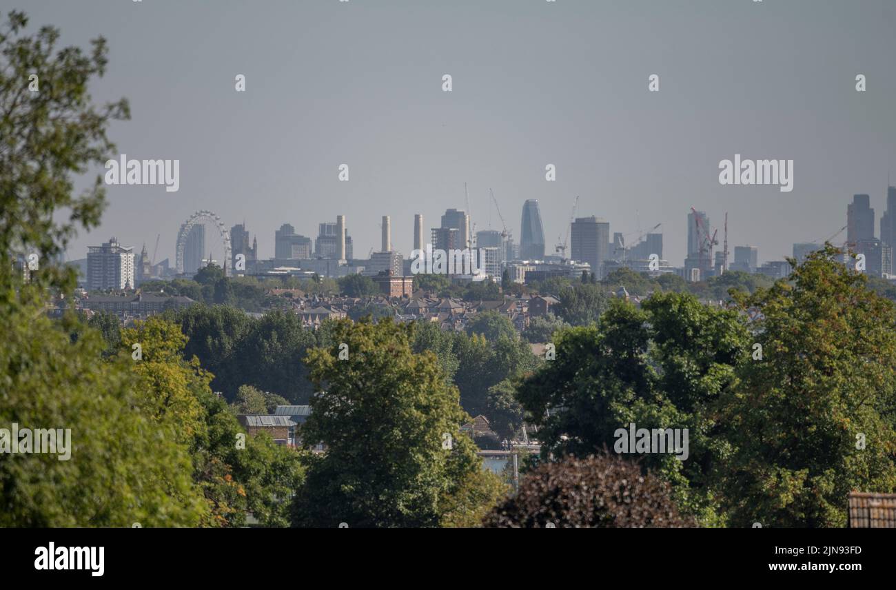 Wimbledon, London, UK. 10 August 2022. Skyscrapers in central London shimmer in the heat haze above houses on Wimbledon Hill as temperatures continue to climb in the South East of England. Credit: Malcolm Park/Alamy Live News. Stock Photo
