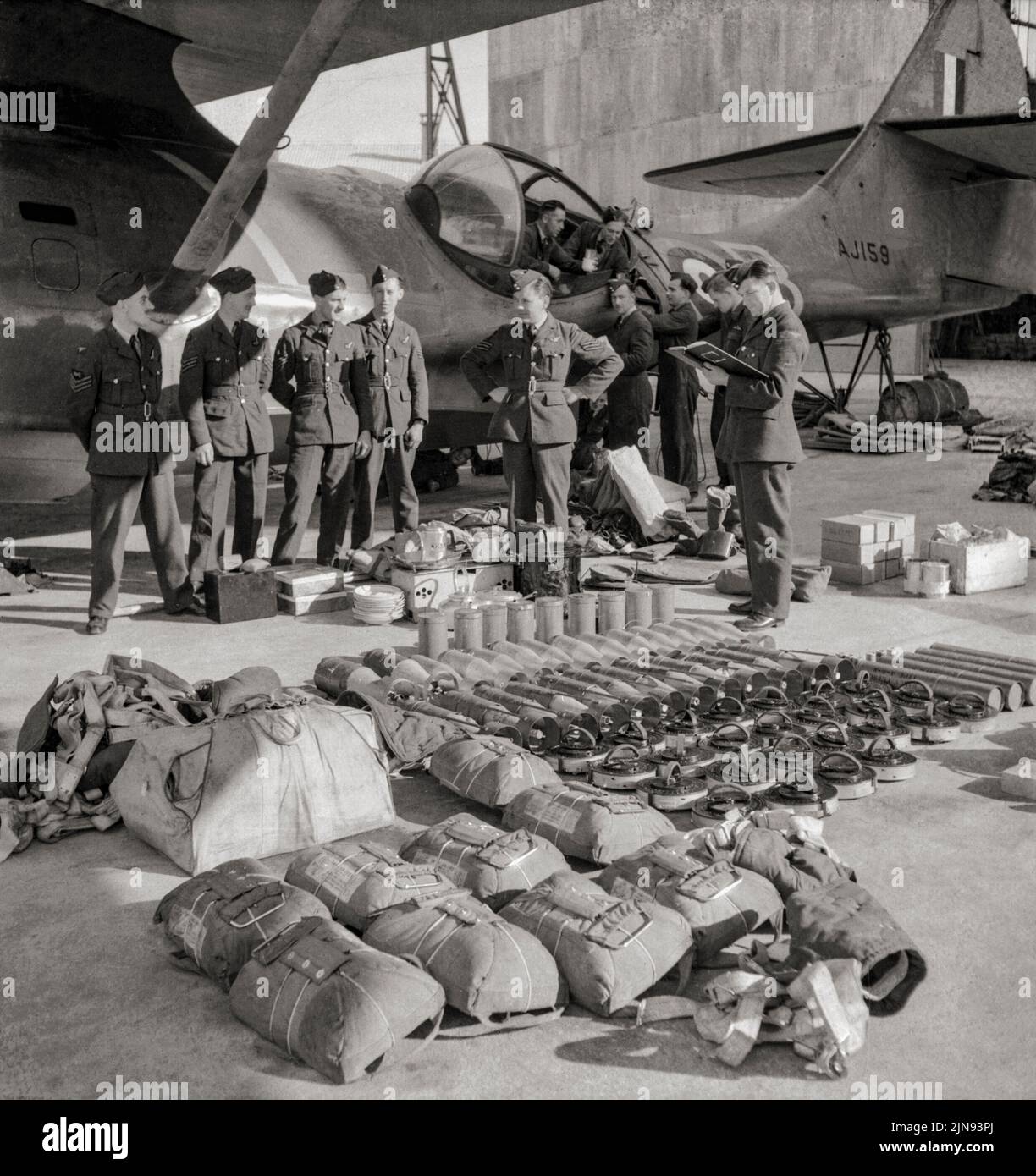 Air and ground crew of No. 202 Squadron RAF check equipment and ordnance issued to Consolidated Catalina Mark I, AJ159 'AX-B', on the slipway at North Front, Gibraltar, in preparation for a patrol.  The Catalina was a flying boat and amphibious aircraft produced in the 1930s and 1940s. During World War II, they were used in anti-submarine warfare, patrol bombing, convoy escort, search and rescue missions (especially air-sea rescue), and cargo transport. Stock Photo