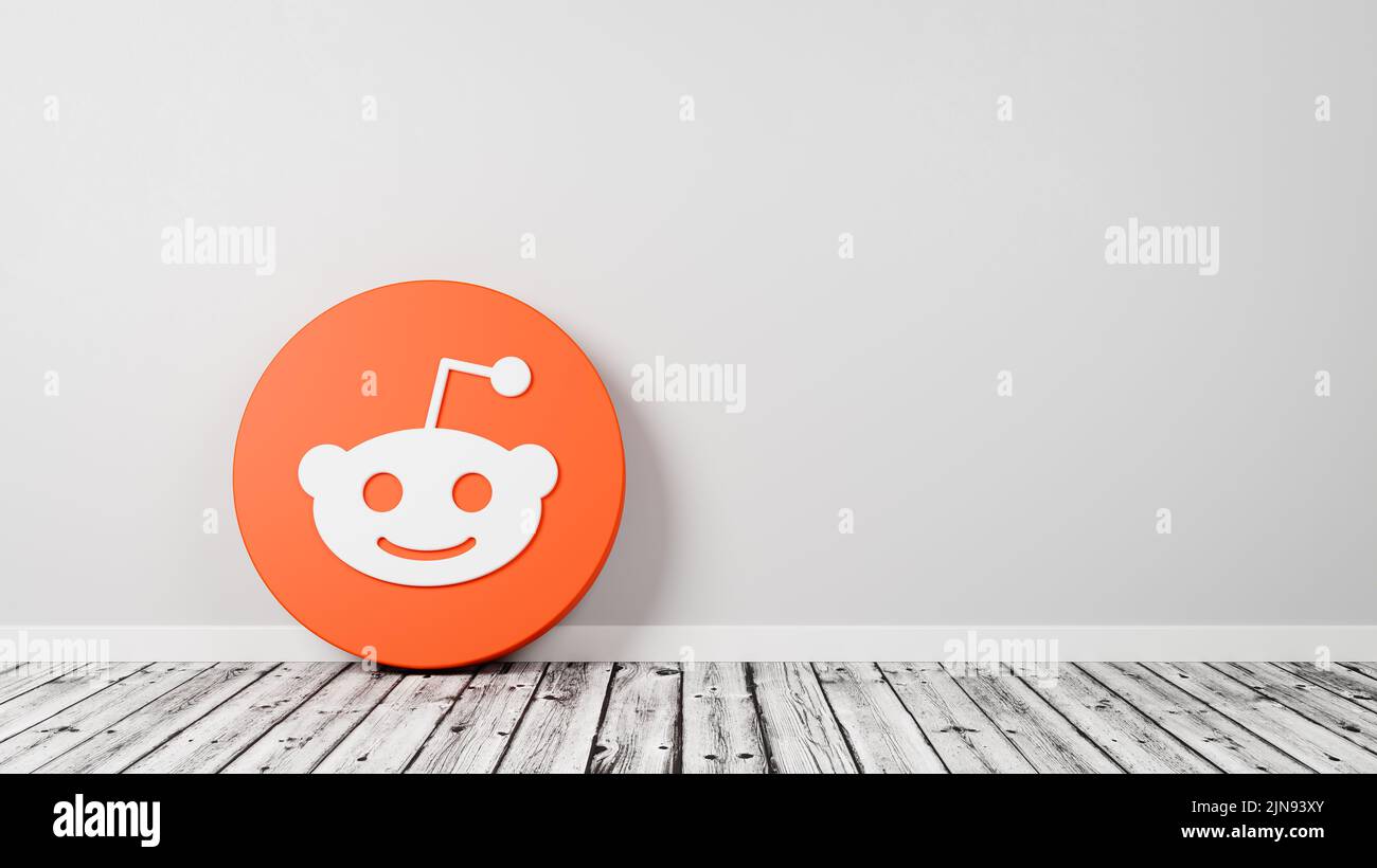 Reddit Logo on Wooden Floor Against Wall Stock Photo