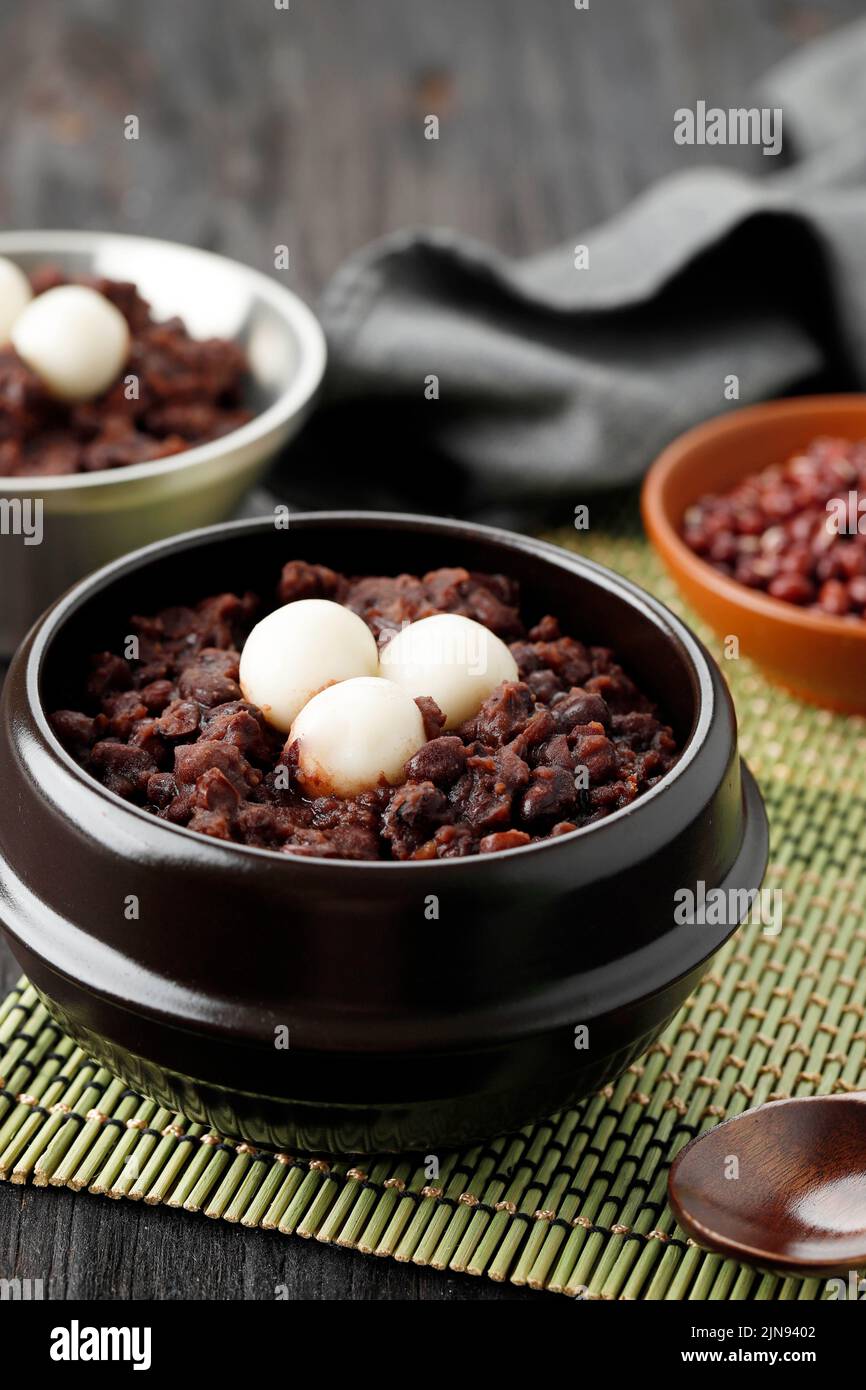 Korean Red Bean Porridge with Rice Cake Topping or Patjuk on Wooden Table Stock Photo