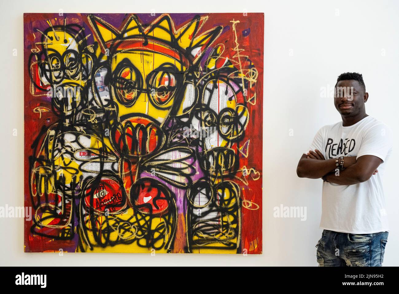 London, UK.  10 August 2022.  Artist Aboudia with his work 'Untitled', 2018, at a preview of ‘Different Throws of Dreams: Aboudia x Dubuffet’, an exhibition at Phillips Berkeley Square exploring the work of the artists Aboudia and Jean Dubuffet and shows how both artists examine the recurring theme of movement in their works through the use of found objects and unorthodox materials.  The works are for sale in an exhibition which runs for the month of August.  Credit: Stephen Chung / Alamy Live News Stock Photo