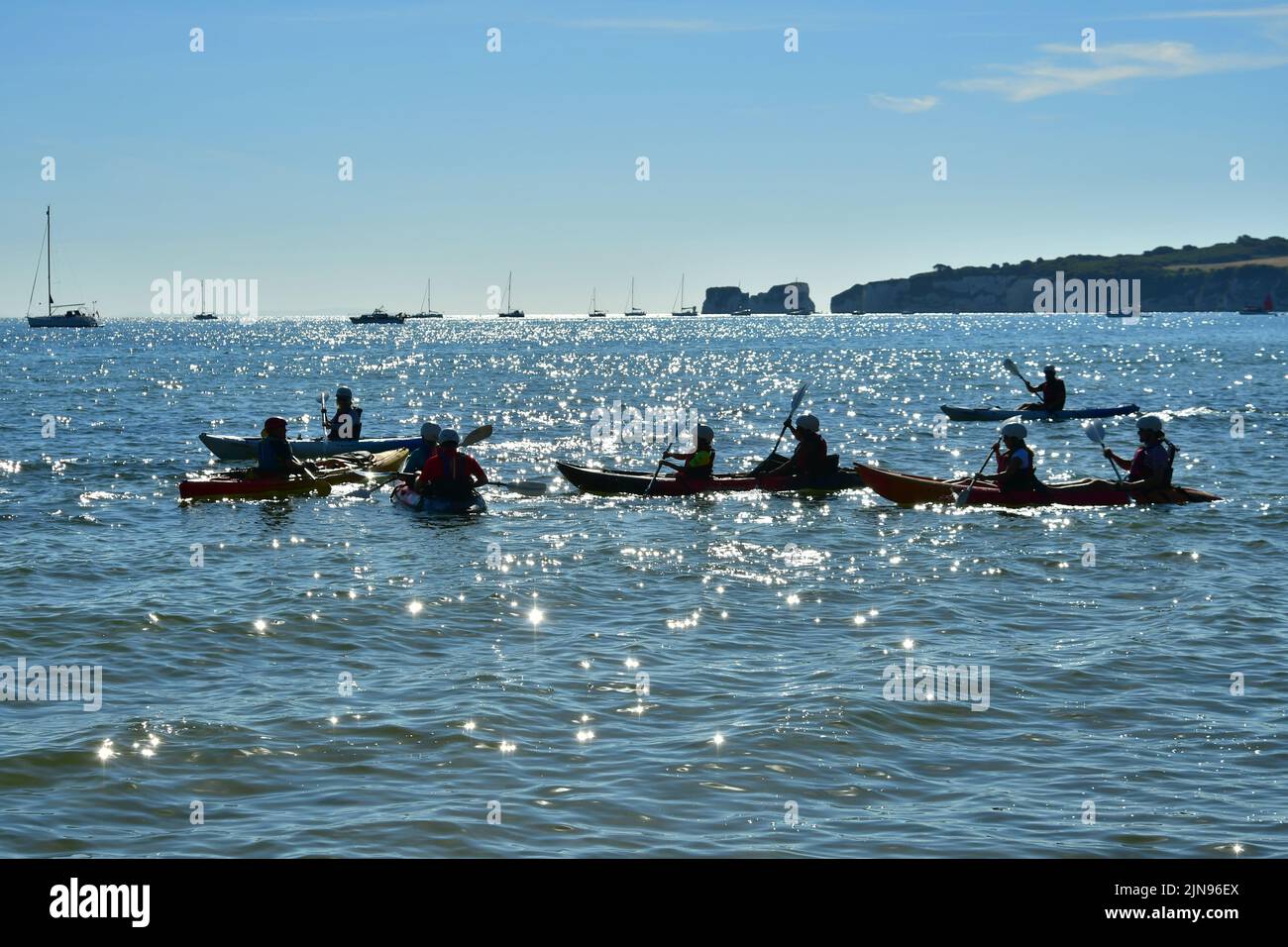 Studland Beach, Shell Bay, Dorset, UK, 10th August 2022, Weather. Hot and sunny at the beginning of another heatwave. A group of kayakers take to the sea in bright morning sunlight. Credit: Paul Biggins/Alamy Live News Stock Photo