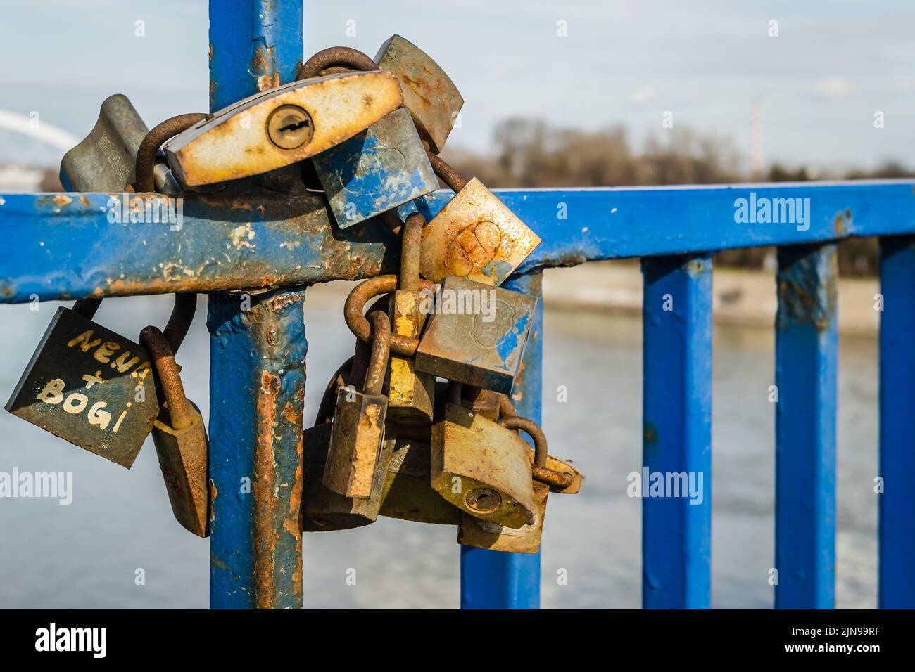 A pile of rusty padlocks on the blue fence of the bridge Stock Photo ...