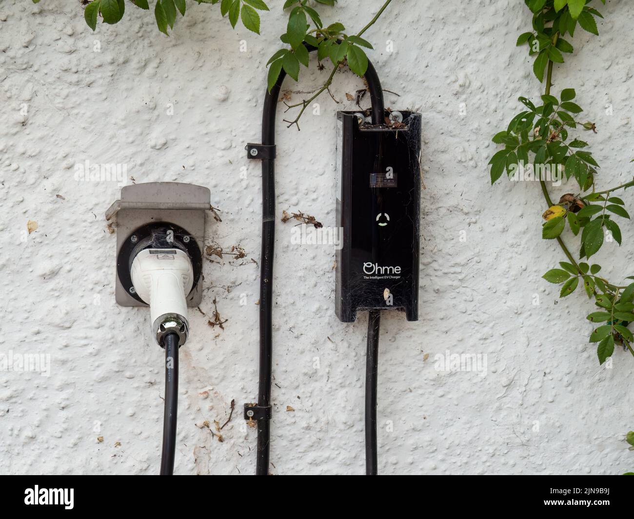 HATHERLEIGH, DEVON, ENGLAND - AUGUST 9 2022: A charger point for an electric car installed in a domestic setting. Brand: Ohme. Stock Photo