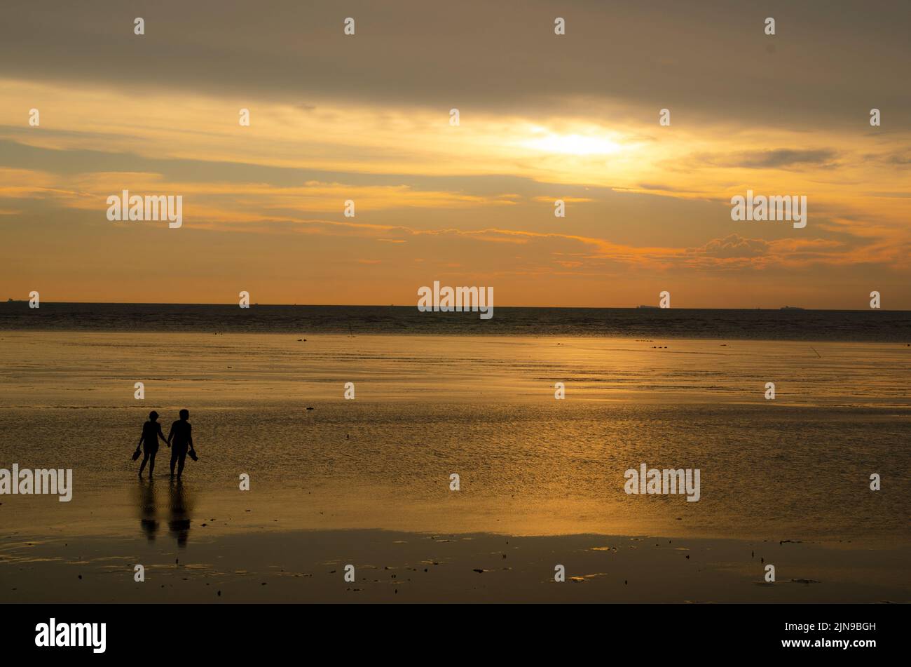 A silhouette of a couple in the beach at a sunset Stock Photo - Alamy