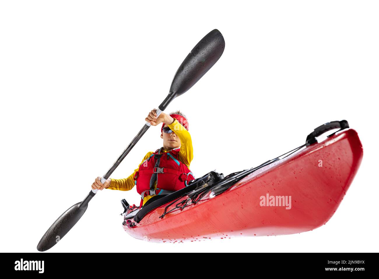 Beginner kayaker in red canoe, kayak with a life vest and a paddle