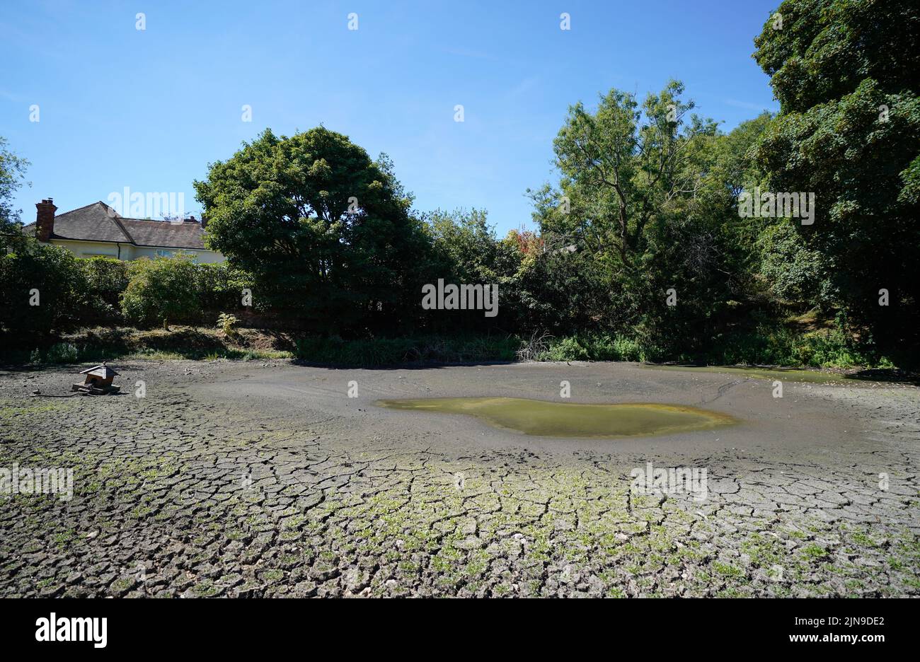 A view of a dried up pond in the village of Northend in Oxfordshire, where Thames Water is pumping water into the supply network following a technical issue at Stokenchurch Reservoir. The Met Office has issued an amber warning for extreme heat covering four days from Thursday to Sunday for parts of England and Wales as a new heatwave looms. Picture date: Wednesday August 10, 2022. Stock Photo