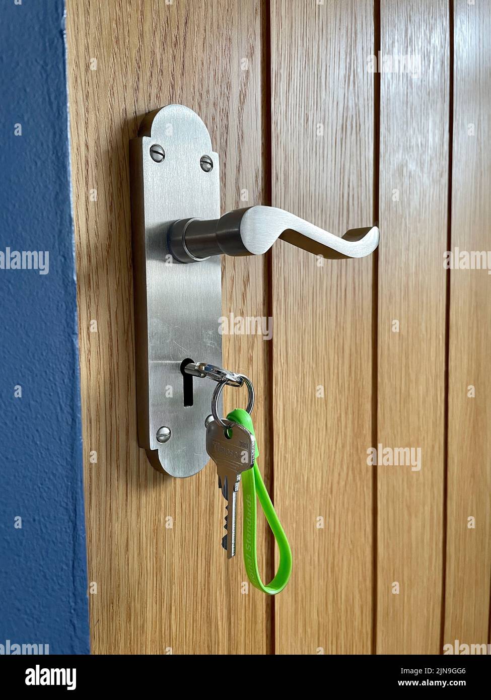 Modern chrome door handle with key in lock Stock Photo Alamy